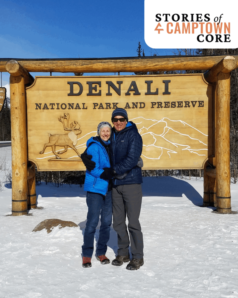 A photo of a donor couple in winter in front of the welcome sign for Denali national park and preserve