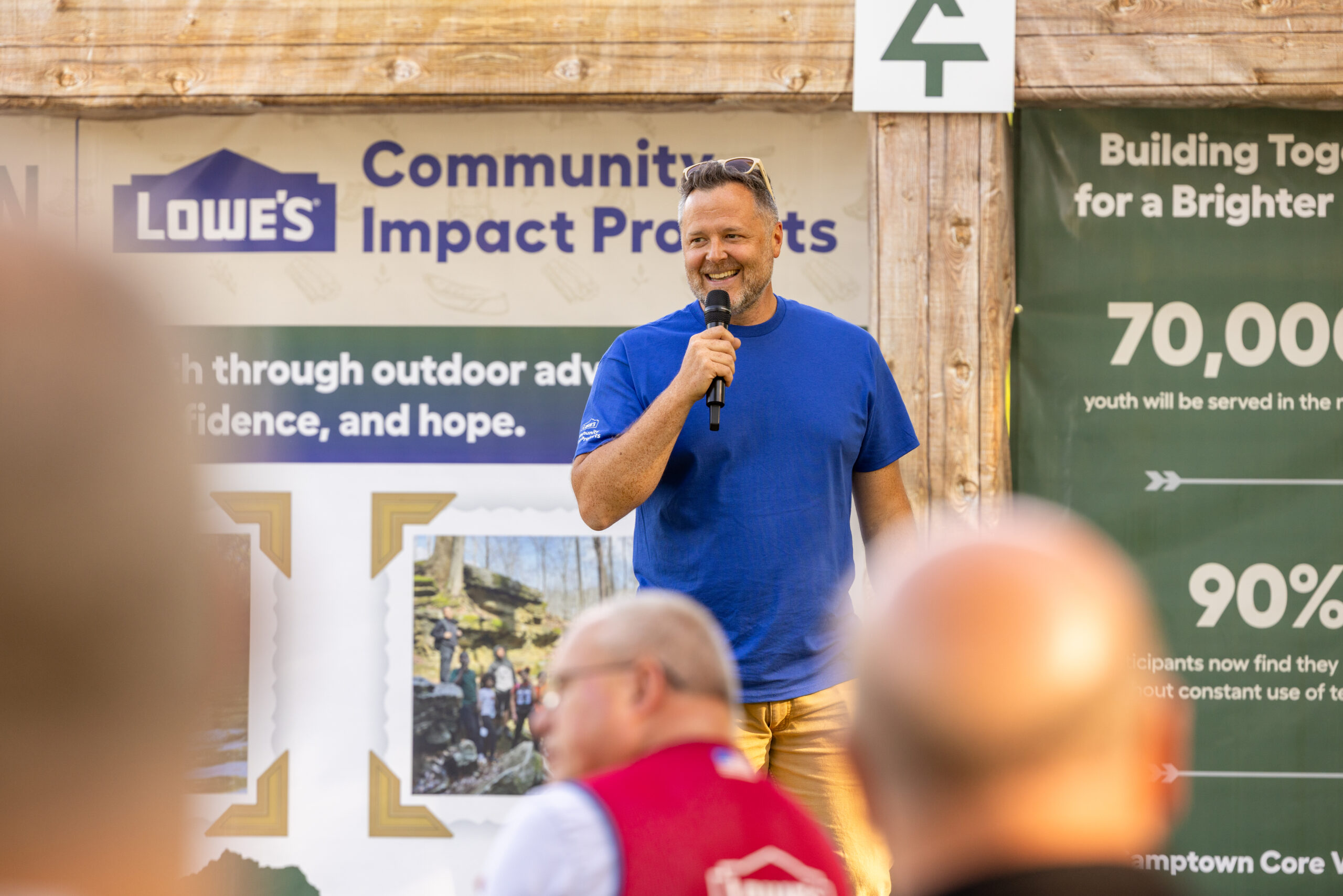 Man standing on stage, speaking to audience.
